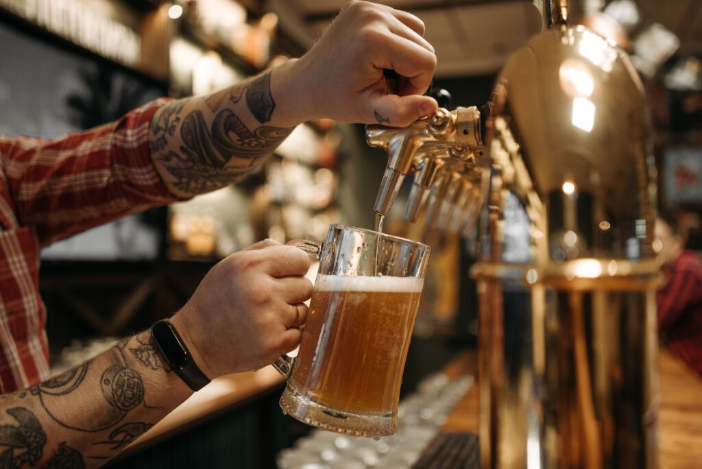 En kald øl med skumtopp som tapper fersk fra ølkranen på en bar eller pub.