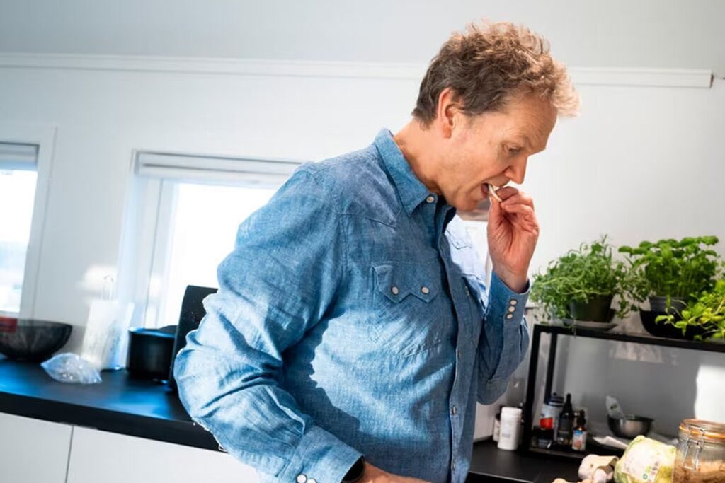 Henrik Berntsen smaker på maten han lager på kjøkkenet.